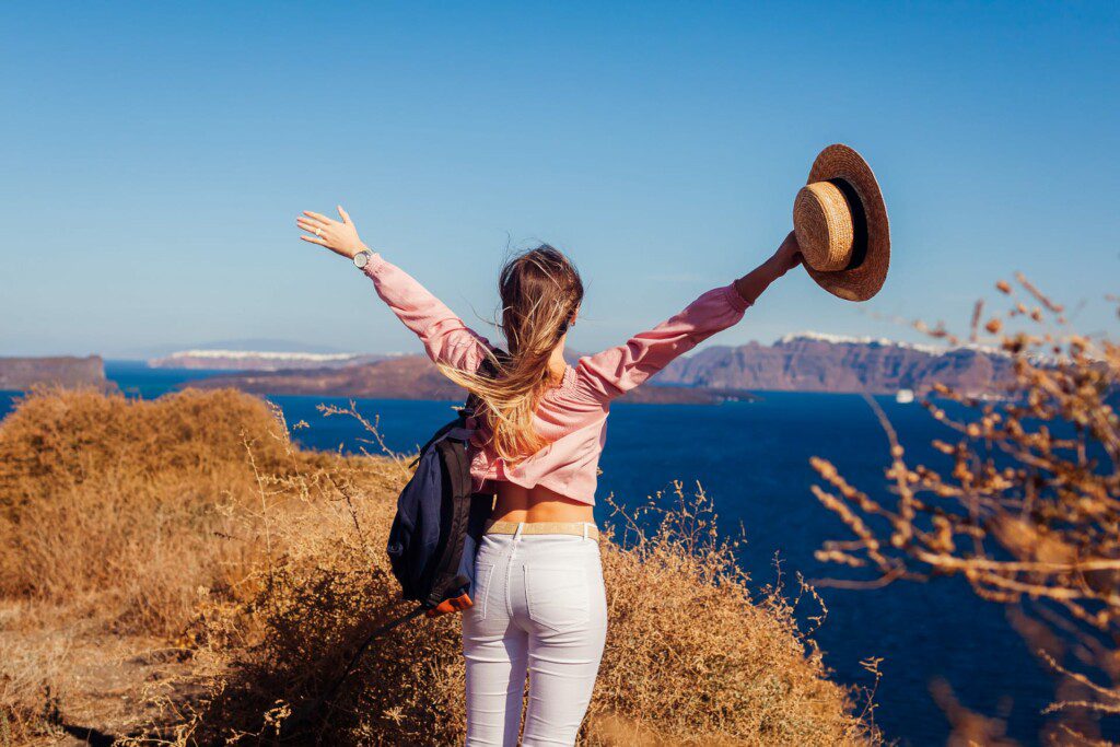 Traveler Woman Walking On Santorini Island, Greece Enjoying Land
